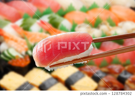 用筷子夾起滋滋作響的鮪魚握壽司 128784302