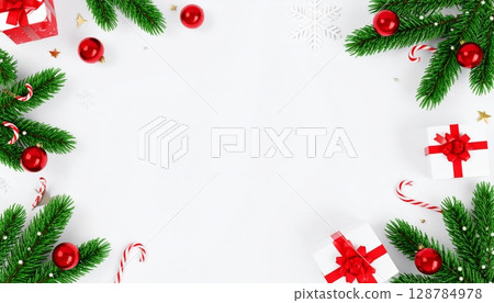 Christmas holiday frame with fir tree branches, festive decorations, and balls on a winter background for greeting card design 128784978