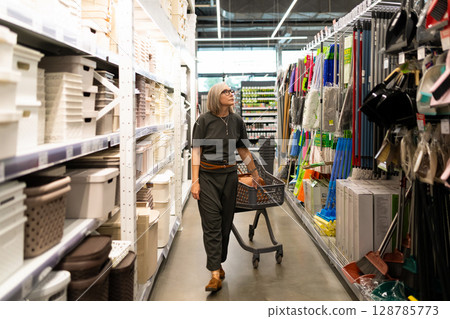 Woman shopping in a retail home improvement store, exploring various departments and browsing 128785773