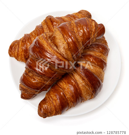Three freshly baked classic delicious fresh organic croissants on white ceramic plate isolated on white background 128785778