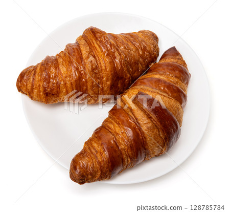 Two freshly baked classic delicious fresh organic croissants on white ceramic plate isolated on white background 128785784