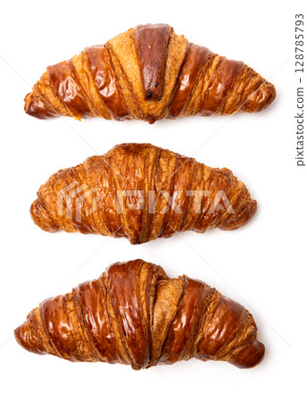Three freshly baked classic delicious fresh organic croissants isolated on white background 128785793