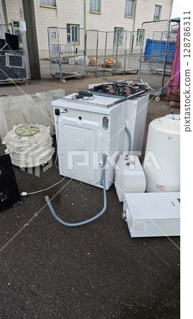Discarded appliances awaiting recycling at an industrial site during daylight hours close to urban surroundings Discarded appliances awaiting recycling at an industrial site during daylight hours close to urban surroundings 128786311