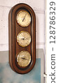 Classic barometer mounted on a wooden frame reflecting vintage craftsmanship in a cozy interior setting 128786329