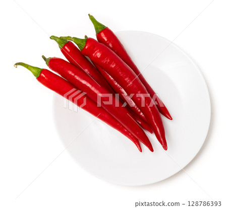 Bunch of red natural organic chili pepper pods on ceramic plate isolated on white background 128786393