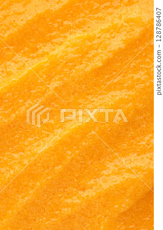 The texture of a orange body scrub with particles. Close-up The texture of a orange body scrub with particles. Close-up 128786407