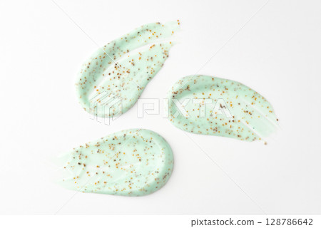Smears of a green body scrub with particles on a white background. Smears of a green body scrub with particles on a white background. 128786642