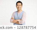 Smiling portrait of a Japanese male nursery teacher in his 40s with his arms folded White background 128787754
