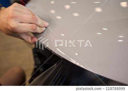 Applying a Protective Film on the Surface of Your Car for Enhanced Durability and Shine 128788099