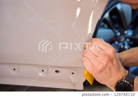 Applying a Protective Film on the Surface of Your Car for Enhanced Durability and Shine 128788110