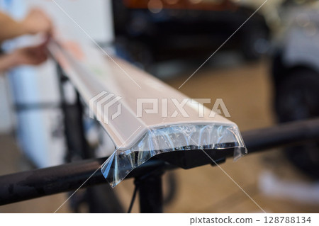 Applying a Protective Film on the Surface of Your Car for Enhanced Durability and Shine 128788134