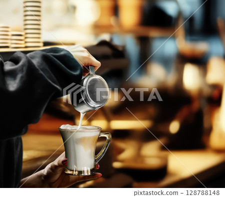 Barista Elegantly Pouring Beautiful Latte Art in a Warm and Cozy Cafe shop 128788148