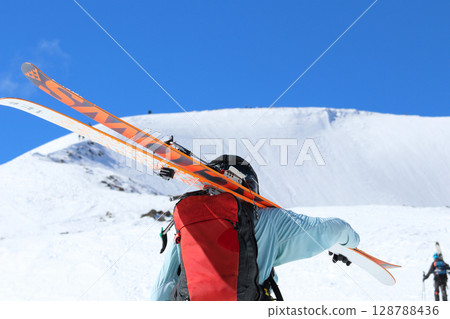 Backcountry skiers climbing snowy mountain in Hakuba Happo-one, Northern Alps, Japan Backcountry skiers climbing snowy mountain in Hakuba Happo-one, Northern Alps, Japan 128788436