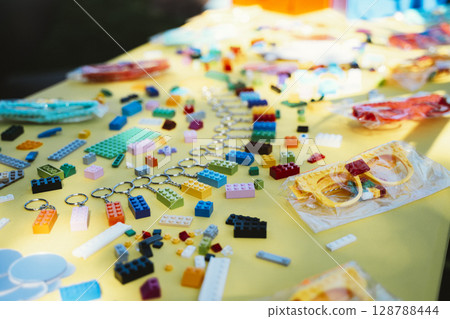 Colorful Plastic Toy Bricks on Yellow Table Surface Colorful Plastic Toy Bricks on Yellow Table Surface 128788444