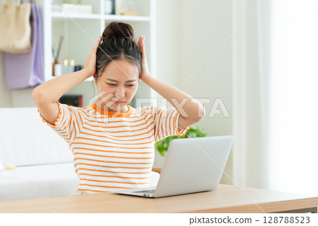 A young woman worried about a computer A young woman worried about a computer 128788523