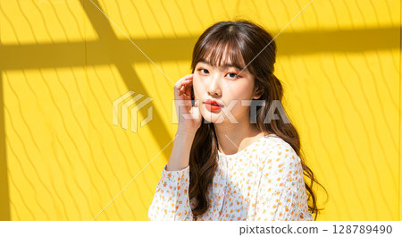 In this captivating image, a person exudes timeless elegance against a vibrant yellow backdrop 128789490