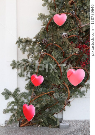 Red hearts on fir branches. 128789646