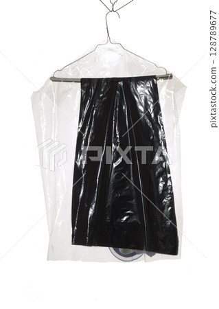 Trousers on dry cleaning hangers under plastic wrap. Trousers on dry cleaning hangers under plastic wrap. 128789677