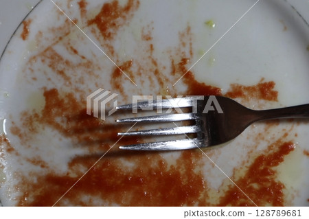 Empty dirty white plate with tomato sauce or ketchup on it. Empty dirty white plate with tomato sauce or ketchup on it. 128789681