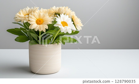 Charming White and Yellow Daisies in a Modern Light Pot on a Minimalist Table Setting Charming White and Yellow Daisies in a Modern Light Pot on a Minimalist Table Setting 128790035