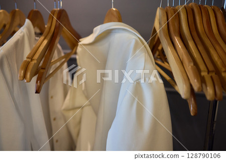 A Stylish and Contemporary Clothing Rack with Wooden Hangers to Display Modern Apparel 128790106