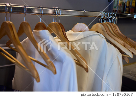 A Stylish and Contemporary Clothing Rack with Wooden Hangers to Display Modern Apparel 128790107
