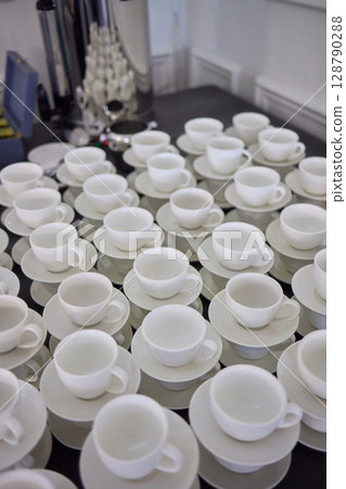 Neatly stacked white coffee cups for elegant events or catering, making a stylish presentation 128790288