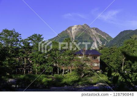 Mount Yakedake and Hotel Shirakabaso bathed in the summer morning sun Mount Yakedake and Hotel Shirakabaso bathed in the summer morning sun 128790848