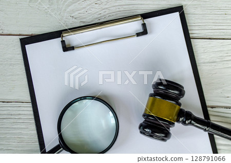 Top view of blank paper, magnifying glass and gavel with customizable space for text. Top view of blank paper, magnifying glass and gavel with customizable space for text. 128791066