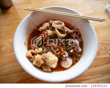 Tom Yum Seafood Noodles with Crispy Pork Cracklings or Pork Rinds. Tom Yum Seafood Noodles with Crispy Pork Cracklings or Pork Rinds. 128791233