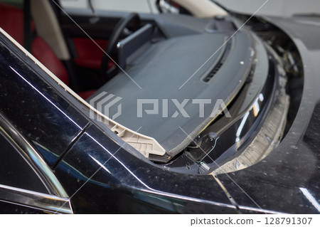 Automobile special workers remove old windscreen or windshield of a car in auto service station garage. Background Automobile special workers remove old windscreen or windshield of a car in auto service station garage. Background 128791307