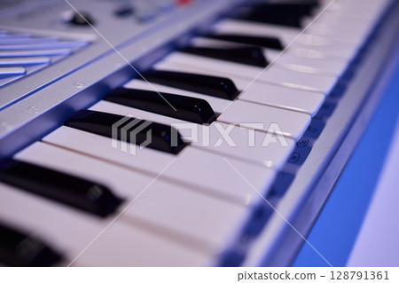 Hands play a keyboard in a modern studio, showcasing creativity and passion for music 128791361