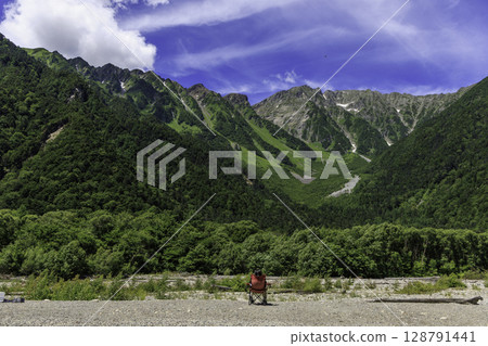 從上高地的小梨子平眺望，夏季穗高山脈的壯麗全景盡收眼底。坐在椅子上的人，表達著與大自然融為一體的感覺。 128791441