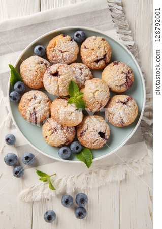Cookies with blueberry filling sprinkled with powdered sugar closeup in the bowl. Vertical top view 128792001