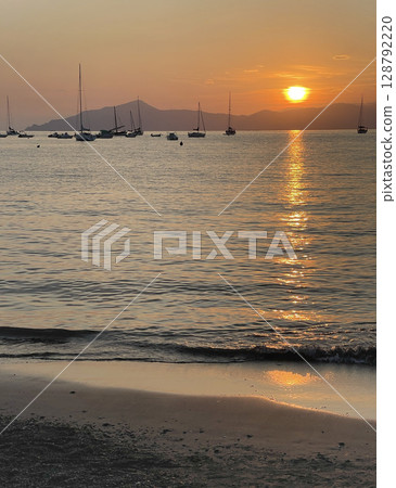 Beach at sunset time in summer on beach. Nature and mountains. Vacation in Liguria, Italy. Background for text. Beach at sunset time in summer on beach. Nature and mountains. Vacation in Liguria, Italy. Background for text. 128792220