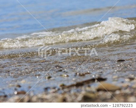 Summer beach landscape with clear waves and pebbles 128792223