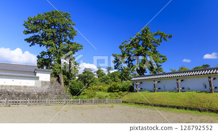 The restored stone walls of Odawara Castle stand out against the blue sky 128792552