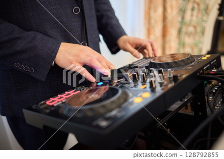 Witness the DJ mixing equipment performing live and in action at a vibrant music event 128792855