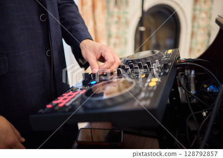 Witness the DJ mixing equipment performing live and in action at a vibrant music event 128792857