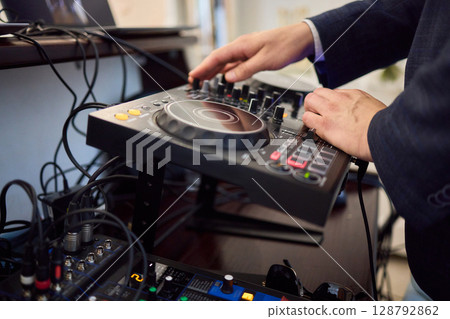 Witness the DJ mixing equipment performing live and in action at a vibrant music event Witness the DJ mixing equipment performing live and in action at a vibrant music event 128792862