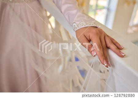 An Elegant Hand Resting on a White Bannister Adorned with Beautiful Delicate Fabric An Elegant Hand Resting on a White Bannister Adorned with Beautiful Delicate Fabric 128792880