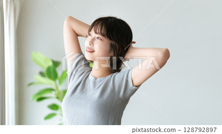A woman stretching by the window 128792897