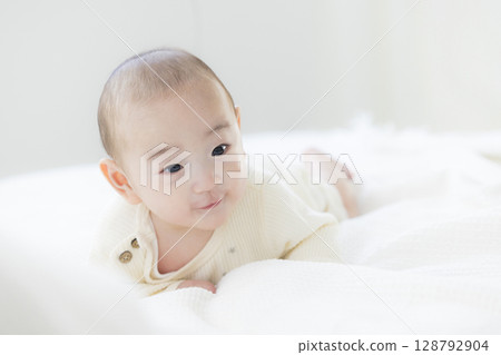 Baby lying on bed 128792904