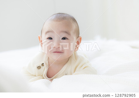 Baby lying on bed 128792905