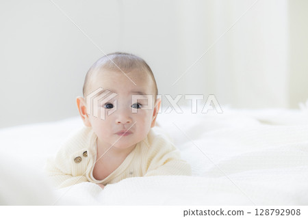 Baby lying on bed 128792908