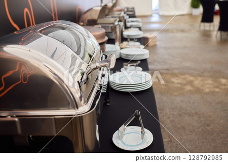 An Elegant Dining Setup Featuring a Silver Cloche and a Unique, Sophisticated Ambiance 128792985