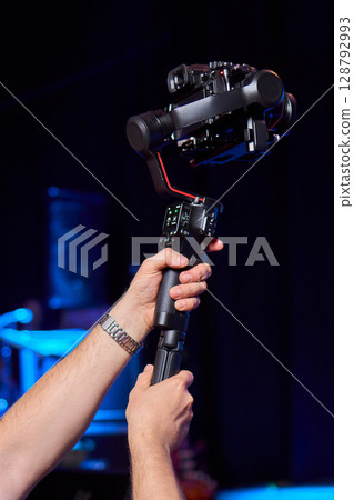 Closeup image showing someone gripping a DSLR camera with an articulated screen Closeup image showing someone gripping a DSLR camera with an articulated screen 128792993