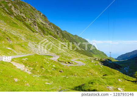 landscape with transfagarasan road in summer. travel romania. scenic view of valley with steep rocky hills and water stream on a sunny morning. alpine scenery of transylvania 128793146