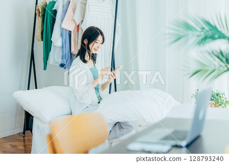 在臥室使用智慧型手機的女人 128793240