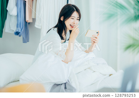 A young woman watching a video on her smartphone 128793253
